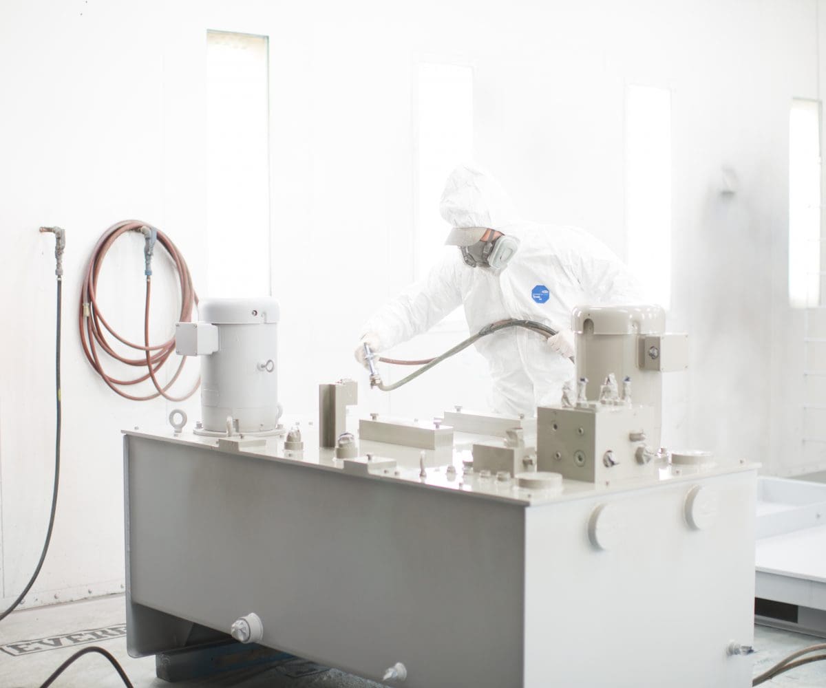 Neff_Press_3_13_shoot_edited-77-1200x1000 A person in white suit and mask working on a machine.