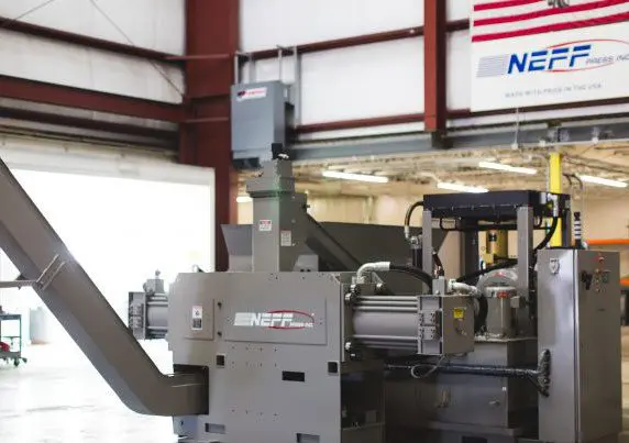 h2_16 A machine in a factory with an american flag hanging from the ceiling.