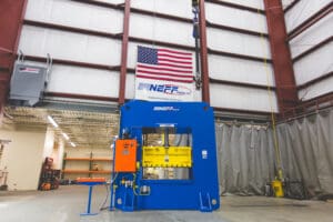 Neff Press hydraulic press in St. Louis factory with American flag and Made with Pride in the USA banner