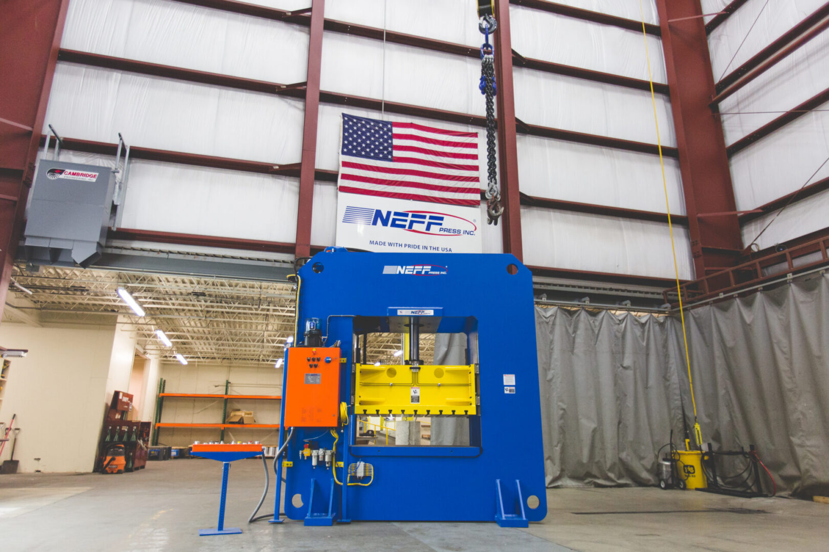 Neff Press hydraulic press in St. Louis factory with American flag and Made with Pride in the USA banner