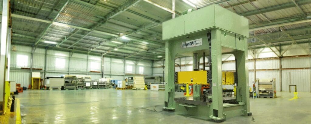 Neff Press column hydraulic stamping press installed in large customer manufacturing facility with yellow safety guards
