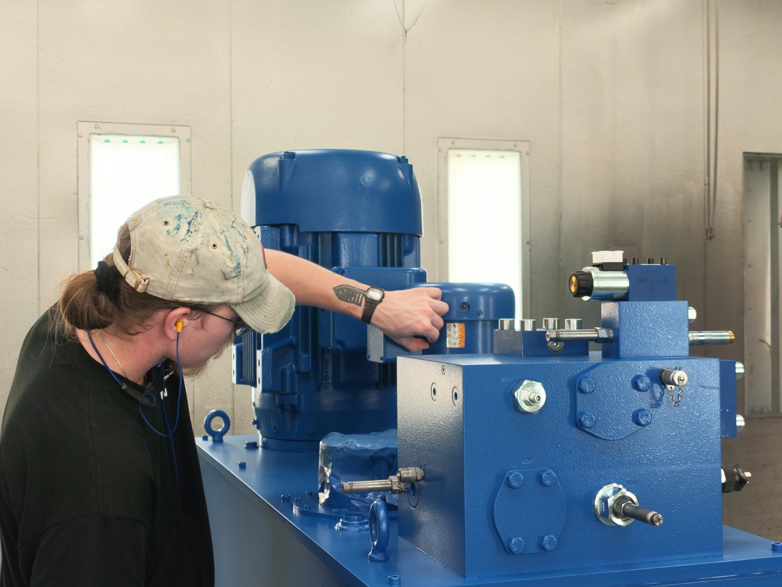 Neff technician assembling a hydraulic power unit with a blue motor and pump