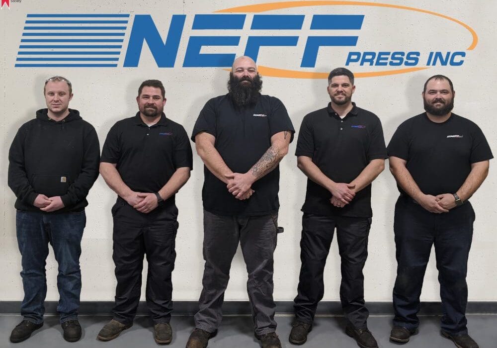 A group of men standing in front of a wall.